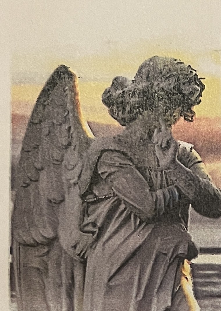 Auf die Neujahrskarte geklebtes Foto: steinerner Engel von hinten vor gelbrotem Abendhimmel