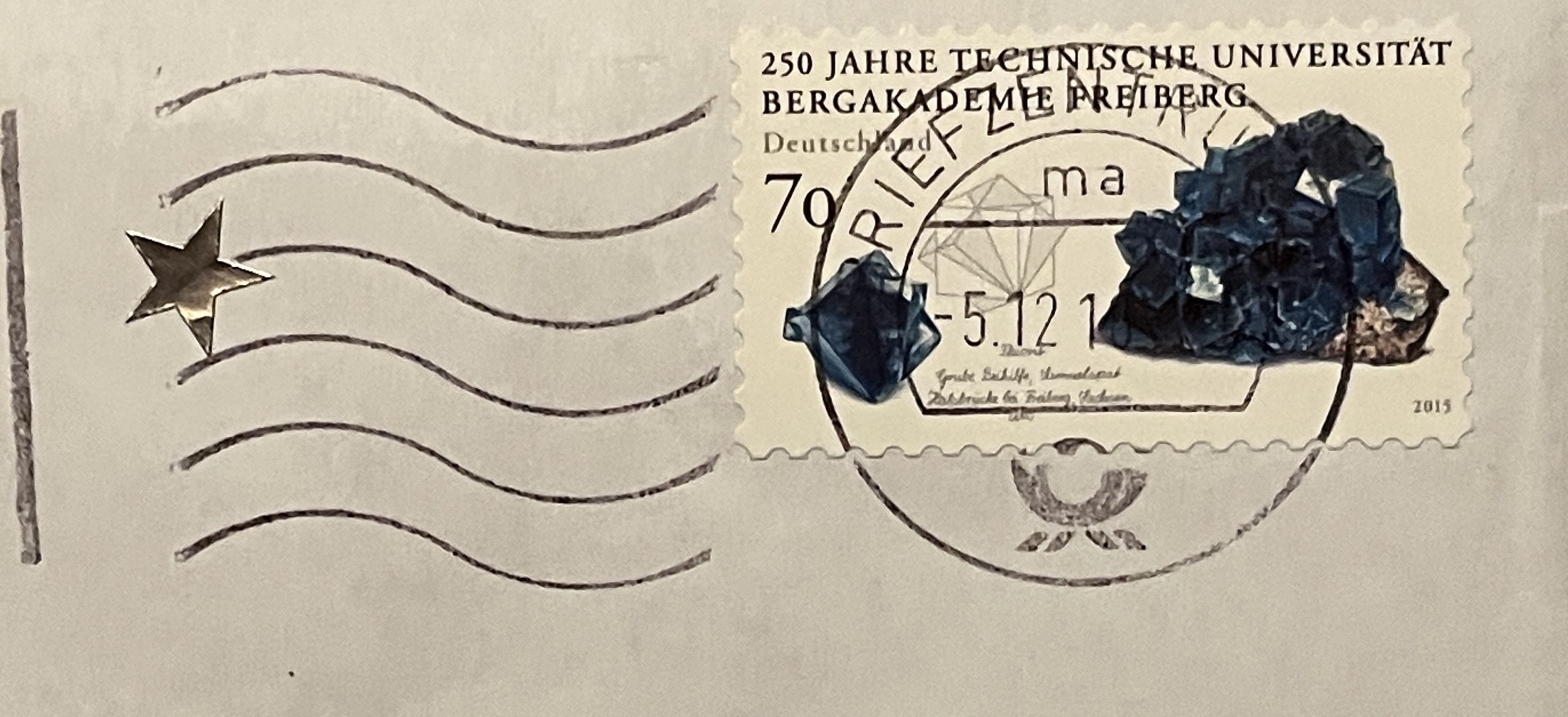 Umschlag: Briefmarke „250 Jahre Technische Universität Bergakademie Freiberg“, aufgeklebter Goldstern und Maschinenstempel des Briefzentrums vom 5. Dezember