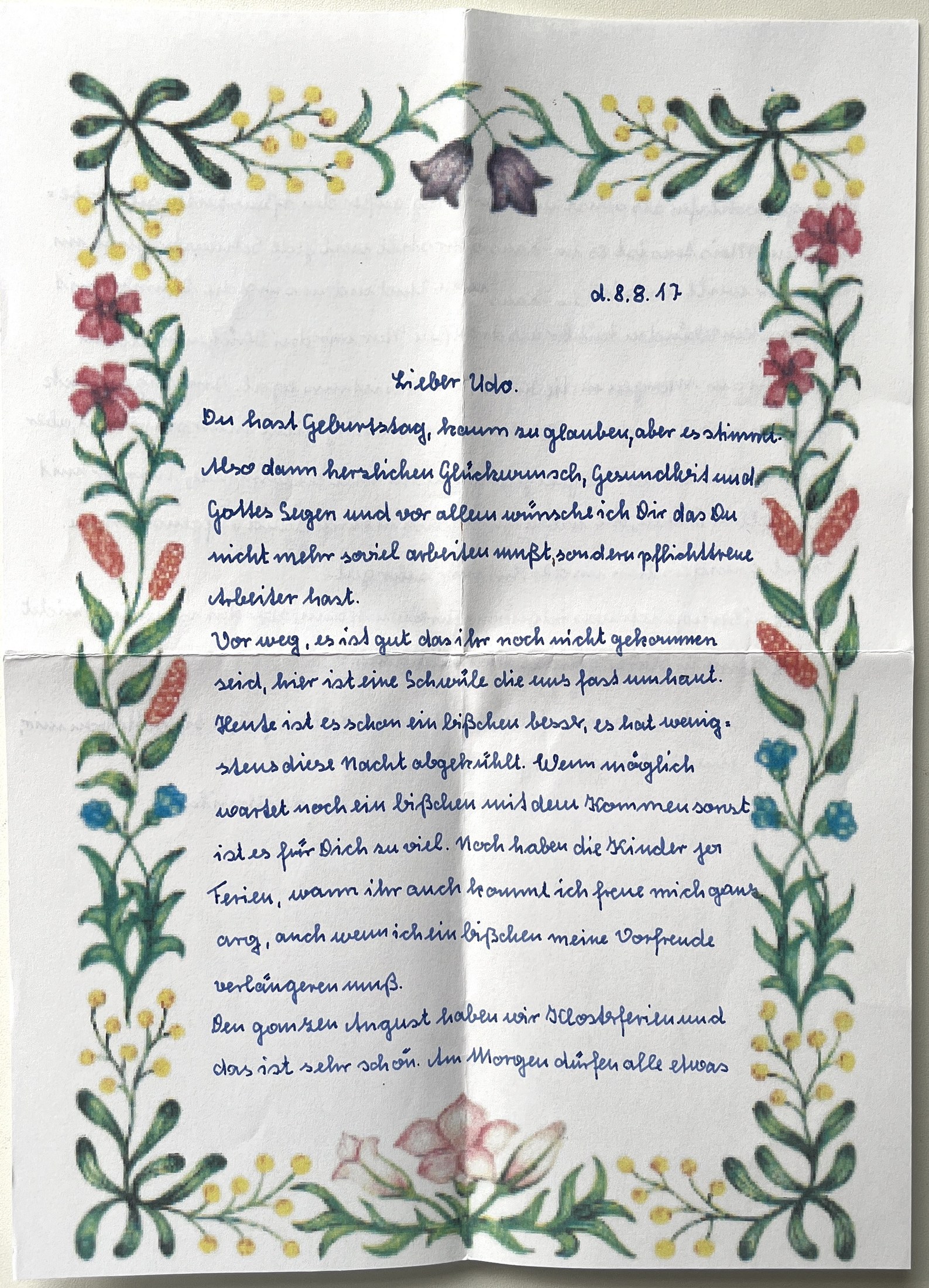 Erste Seite mit gemalter Blumenbordüre, Datumszeile und Geburtstagsglückwunsch