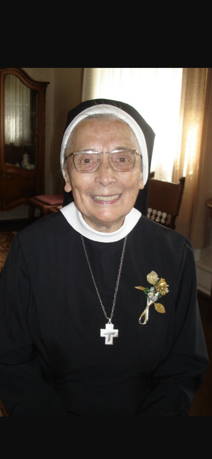 Schwester Monika, festlich mit Ansteckschmuck
