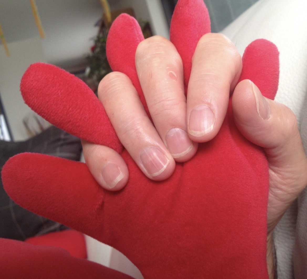 Eine Hand liegt in einer roten Plüschhand